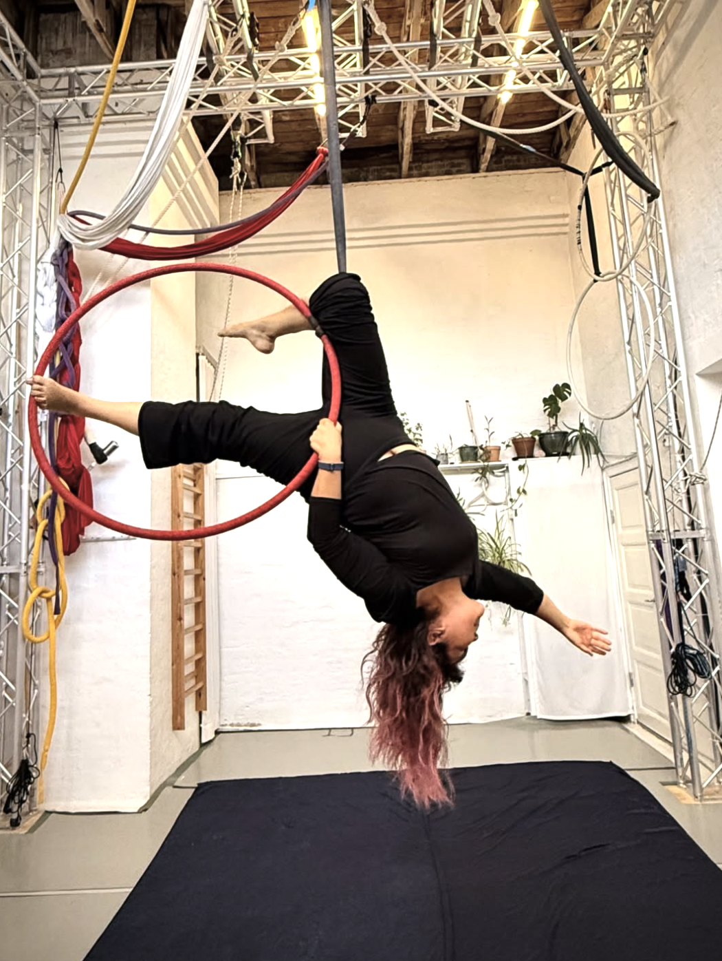 Veronica practising aerial arts on a red hoop